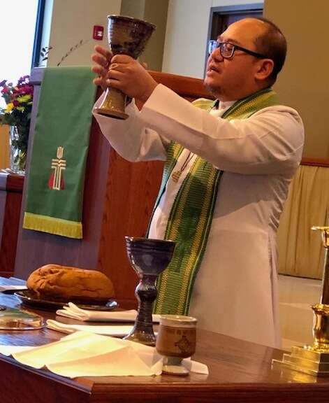 Pastor Tim holding communion cup