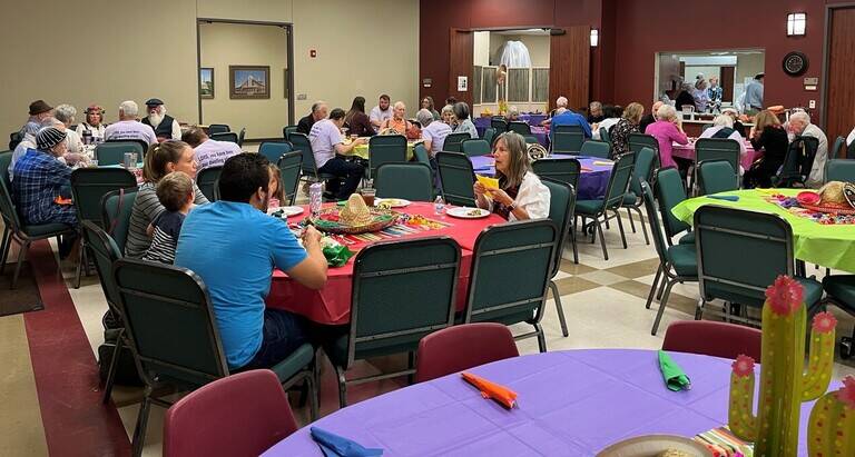 Church members enjoying taco meal in Fellowship Hall