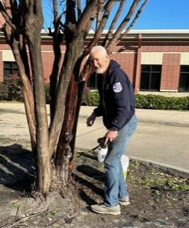 Garry Nelson Treating Crepe Myrtles with Pesticide on Church's Work Day.